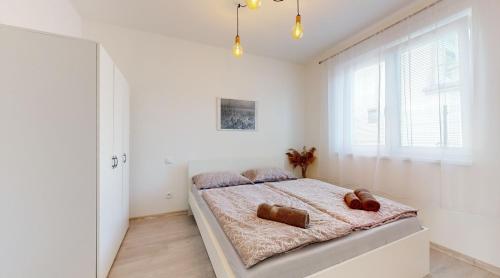 Un dormitorio con una cama con dos ositos de peluche encima. en SALAN Apartman Sereď, en Seredʼ