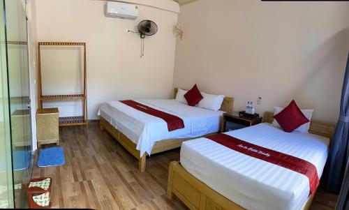 a hotel room with two beds and a mirror at Tam Coc Westlake Homestay in Ninh Binh