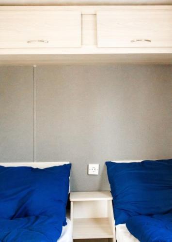 a bed with blue pillows in a room at Luxe chalet in Harderwijk