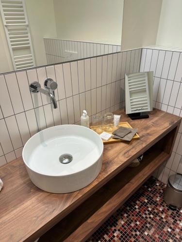 a bathroom with a white sink on a wooden counter at La Différence in Vichten