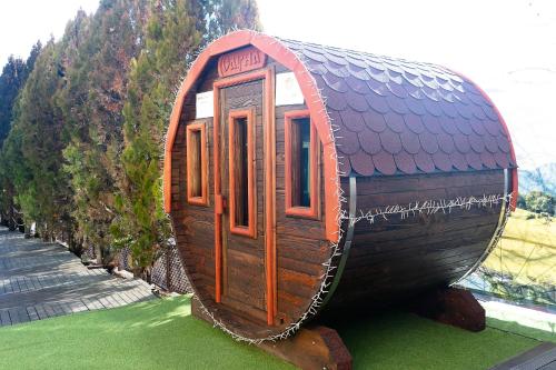 a small wooden house on display in a field at SPA Hotel Olymp in Velingrad