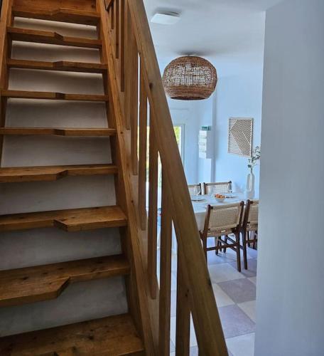 - un escalier en bois dans une salle à manger avec une table dans l'établissement Sejour détente en bord de mer au gîte des falaises, à Plouha