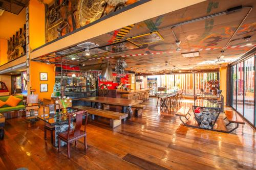 a restaurant with wooden tables and benches in a room at MeStyle Place Hotel in Bangkok