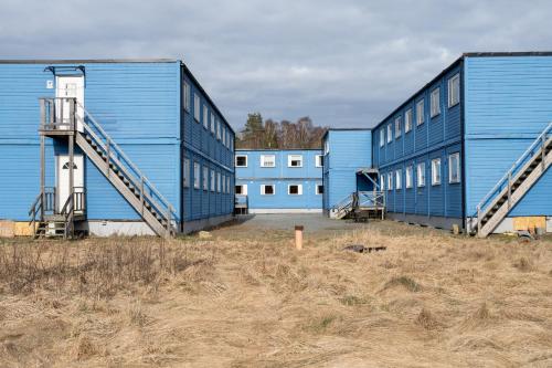 a row of blue buildings in a field at Smart Hotels in Säve