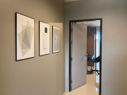a hallway with paintings on the wall and a mirror at Chiangrai Airport, Private & Cozy house in Ban Du