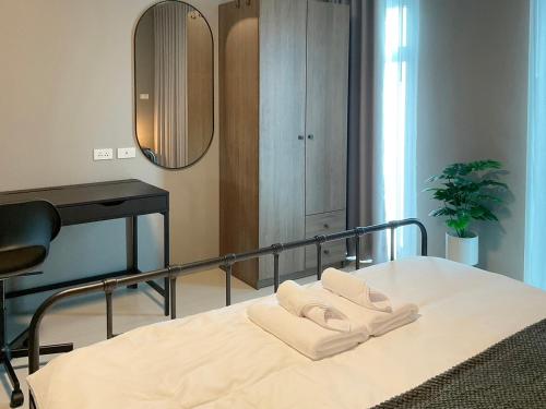 a bedroom with a bed with two towels on it at Chiangrai Airport, Private & Cozy house in Ban Du