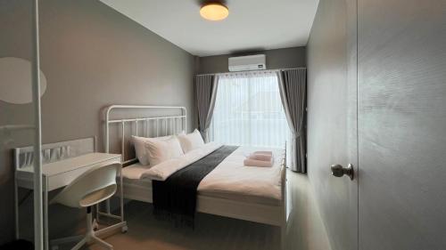 a small bedroom with a bed and a window at Chiangrai Airport, Private & Cozy house in Ban Du