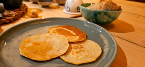 three pancakes on a blue plate on a table at Gîte L'Ostau 4 étoiles Les Échappées Belles in Antignac