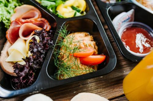 a lunch box with three trays of food on a table at Old Town Heart XVIII - Downtown Luxury in Warsaw