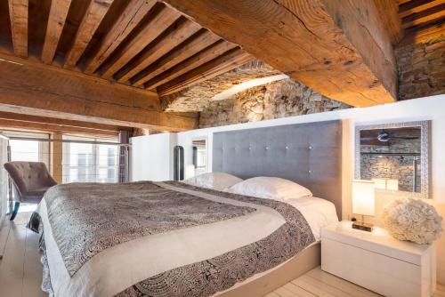 a bedroom with a large bed and a wooden ceiling at Le Carré Mercière , Appartements de Luxe au cœur de Lyon, Loft et Studio in Lyon
