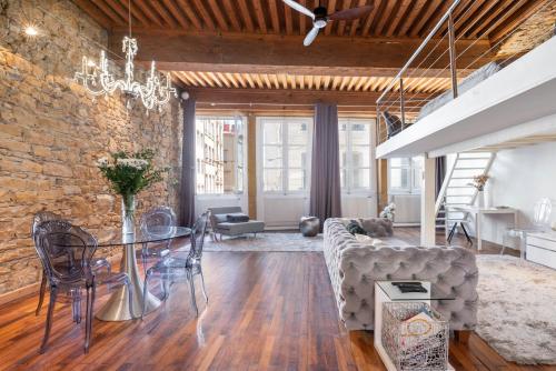- une salle à manger et un salon avec un mur en briques dans l'établissement Le Carré Mercière , Appartements de Luxe au cœur de Lyon, Loft et Studio, à Lyon