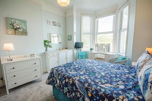 a bedroom with a bed and a desk and window at Llety in Criccieth