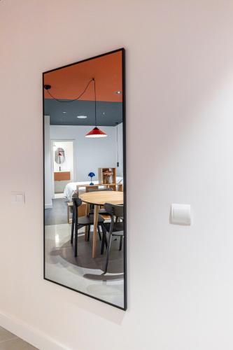 a mirror on a wall in a room with a table at Estudios Arturo Soria by Rent Me in Madrid