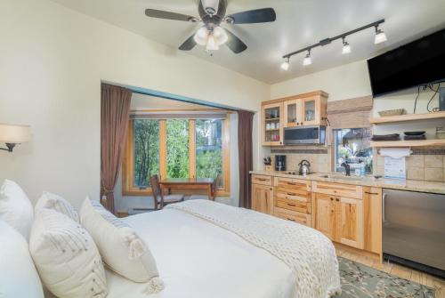 a bedroom with a large bed and a kitchen at Charming Studio w Kitchenette, Hot Tub Near River condo in Telluride