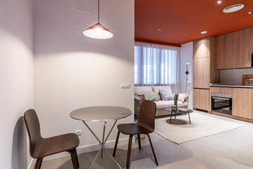 a living room with a table and chairs and a couch at Estudios Arturo Soria by Rent Me in Madrid