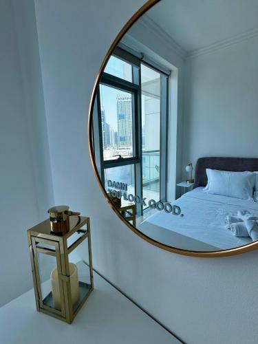 a mirror in a bedroom with a bed and a window at Noma Fairview - Burj Khalifa view stunning apartment in Business Bay in Dubai