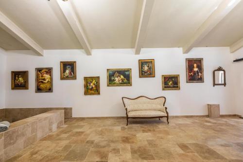 a room with a chair and paintings on the wall at Domaine du Reginu in Santa-Reparata-di-Balagna
