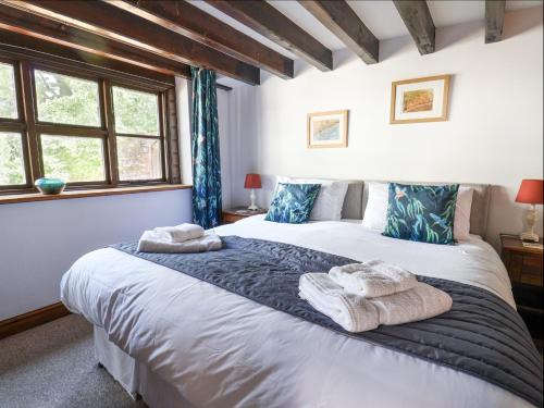 una camera da letto con due letti con asciugamani sopra di Coach Cottage a Colyton