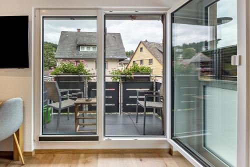 a room with a balcony with chairs and a table at Haus an der Haslach in Lenzkirch