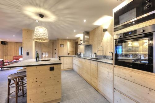 une grande cuisine avec des placards en bois et un grand îlot dans l'établissement Picherie bas - 10Pax - Calme - Vue montagne, à Saint-Gervais-les-Bains