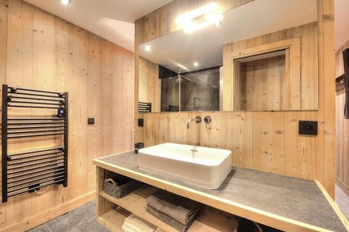 La salle de bains est pourvue d'un lavabo et de murs en bois. dans l'établissement Picherie bas - 10Pax - Calme - Vue montagne, à Saint-Gervais-les-Bains
