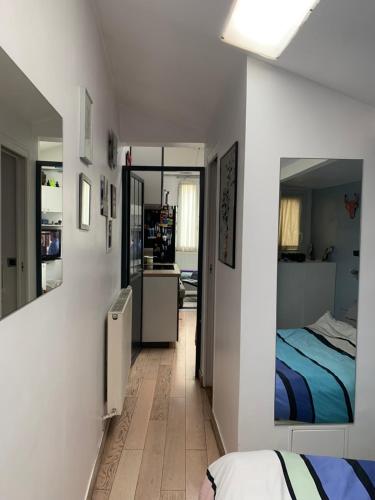 Un dormitorio con una cama y un espejo en la pared. en Appartement Cosy tout équipé, en Colombes