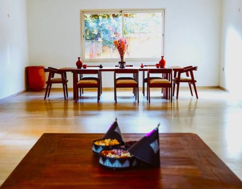 a dining room table with chairs and a table with a bowl at Villa contemporaine - 6 chambres - piscines et jacuzzi in Marrakech