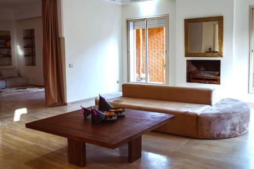 a living room with a couch and a coffee table at Villa contemporaine - 6 chambres - piscines et jacuzzi in Marrakech