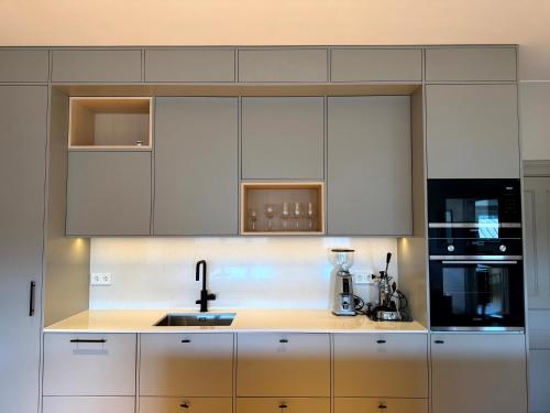 a kitchen with white cabinets and a sink at The Embassy in Lund