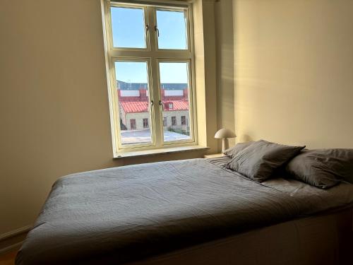 a bed in a bedroom with a large window at The Embassy in Lund