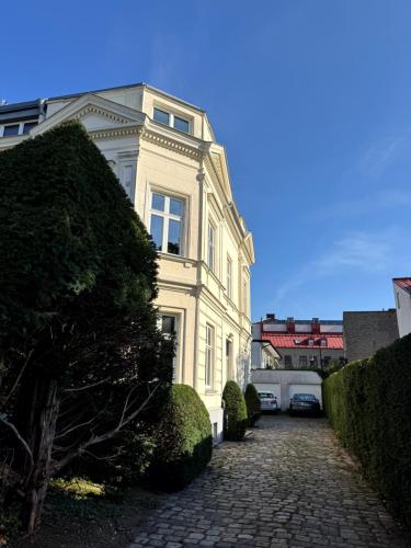 a large white building on a cobblestone street at The Embassy in Lund