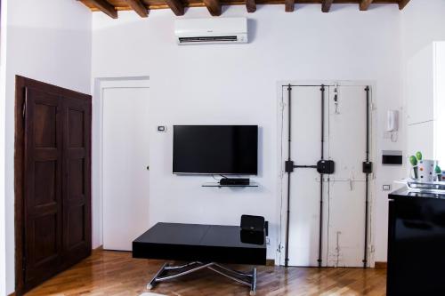 a living room with a tv on a white wall at PgrHome Luxury Apartments Parione in Rome