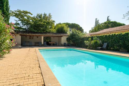une piscine devant une maison dans l'établissement L'ensemble du gîte de Tante Berthe, à Camaret-sur-Aigues
