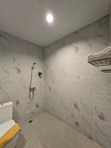 a bathroom with a shower with white marble tiles at Jomtien Plaza Residence in Jomtien Beach