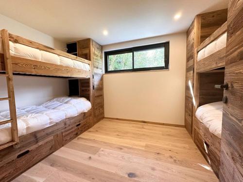 deux lits superposés dans une chambre avec fenêtre dans l'établissement Chalet Le 1853, à Chamonix-Mont-Blanc
