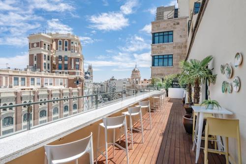 a balcony with chairs and tables and a view of the city at Vincci Capitol in Madrid