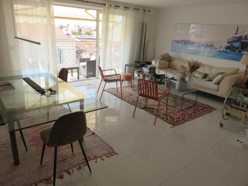 un salon avec une table en verre et des chaises dans l'établissement Superbe Penthouse Plein Ciel Vue Panoramique, à Cannes