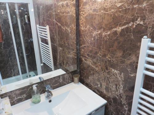 une salle de bain avec un lavabo et un miroir dans l'établissement Superbe Penthouse Plein Ciel Vue Panoramique, à Cannes