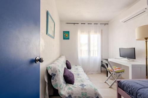 a bedroom with a couch and a desk with a computer at Casa Colomer in Cadaqués