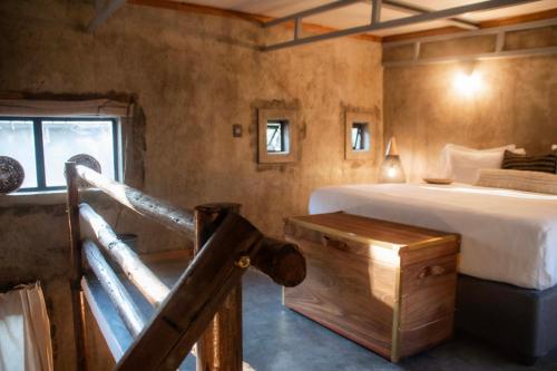 a bedroom with a bed and a desk in a room at Chobe House Villa and Chalets in Kasane