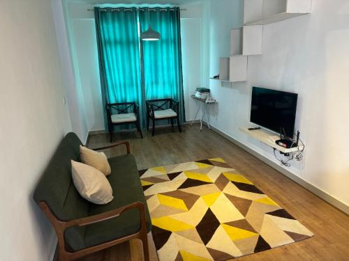 a living room with a couch and a television at Spice Tunas 3B2B House in Bayan Lepas
