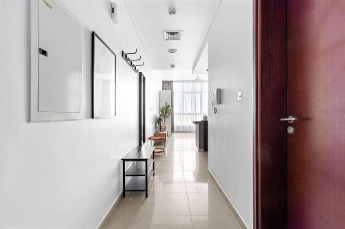 a hallway with white walls and a door at Silkhaus Vacation Homes in Hydra Avenue Large Studio Near Reem Park in Abu Dhabi