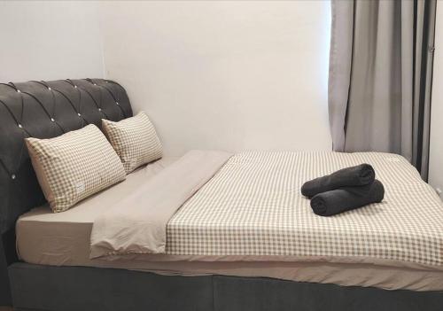 a bed with a black headboard and two towels on it at GM B-1205 TWO BEDROOMS Cozy Netflix BySTAY in Iskandar Puteri