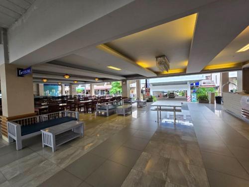a restaurant with tables and benches in a building at Jomtien Plaza Residence in Jomtien Beach
