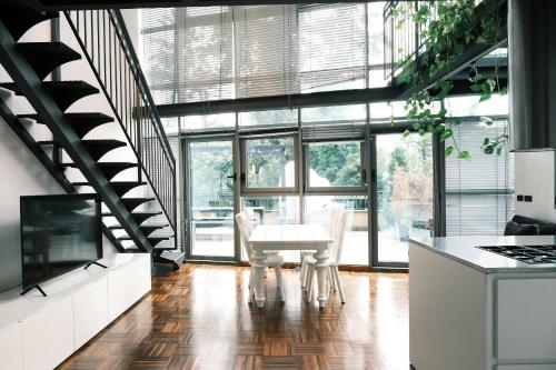 eine Küche mit einem Tisch und Stühlen sowie eine Treppe in der Unterkunft ComeCasa Terraced Apartment in Porta Romana in Mailand