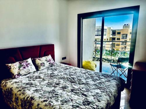 a bedroom with a bed and a view of a balcony at Luxueux Appartement ensoleillé vue sur mer in Pont Blondin