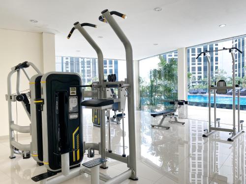 a gym with cardio equipment in a building at Cozy and Comfort 2BR at Pollux Chadstone Apartment By Travelio in Cikarang