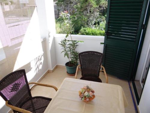 a table and two chairs on a balcony with a window at Studio in Pag/Insel Pag 15956 in Stari Okić