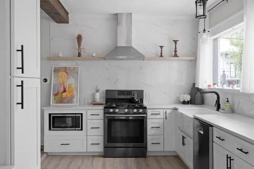 a kitchen with white cabinets and a black stove at Atlanta's Secret Getaway in Atlanta