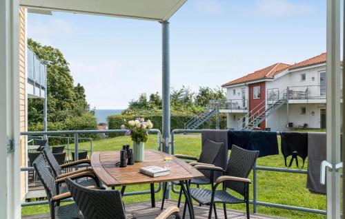 a patio with a table and chairs on a balcony at Gudhjem Søpark Lejl 33 in Gudhjem